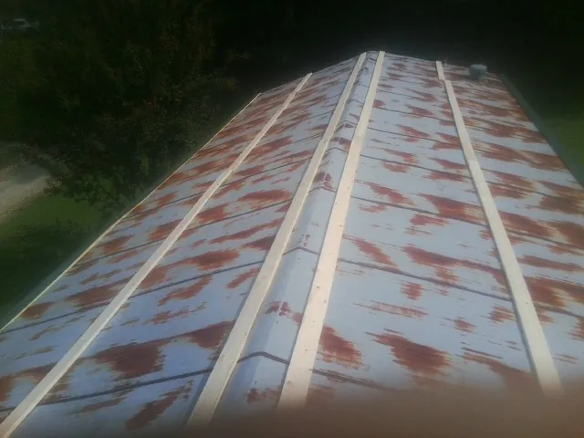Rusted metal roof panels with new wood purlins before replacement — Storm Damage Roof Repair in Nephi by Roofing Brothers