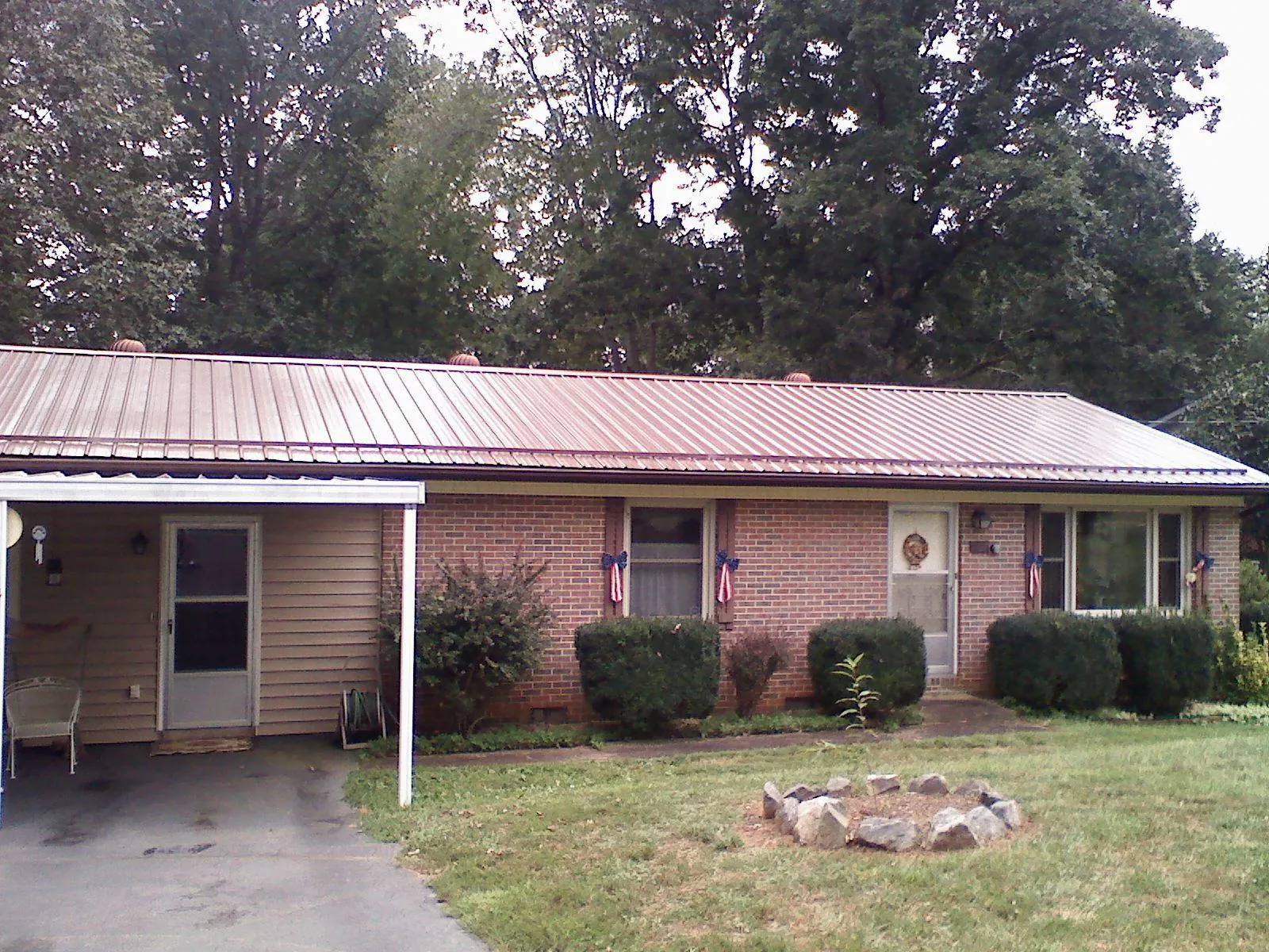 Bronze metal roof and carport on a brick ranch home — Roof Repair work by our crew in Nephi